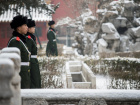 Chinese paramilitary guards stand in the snow at the Forbidden City in Beijing