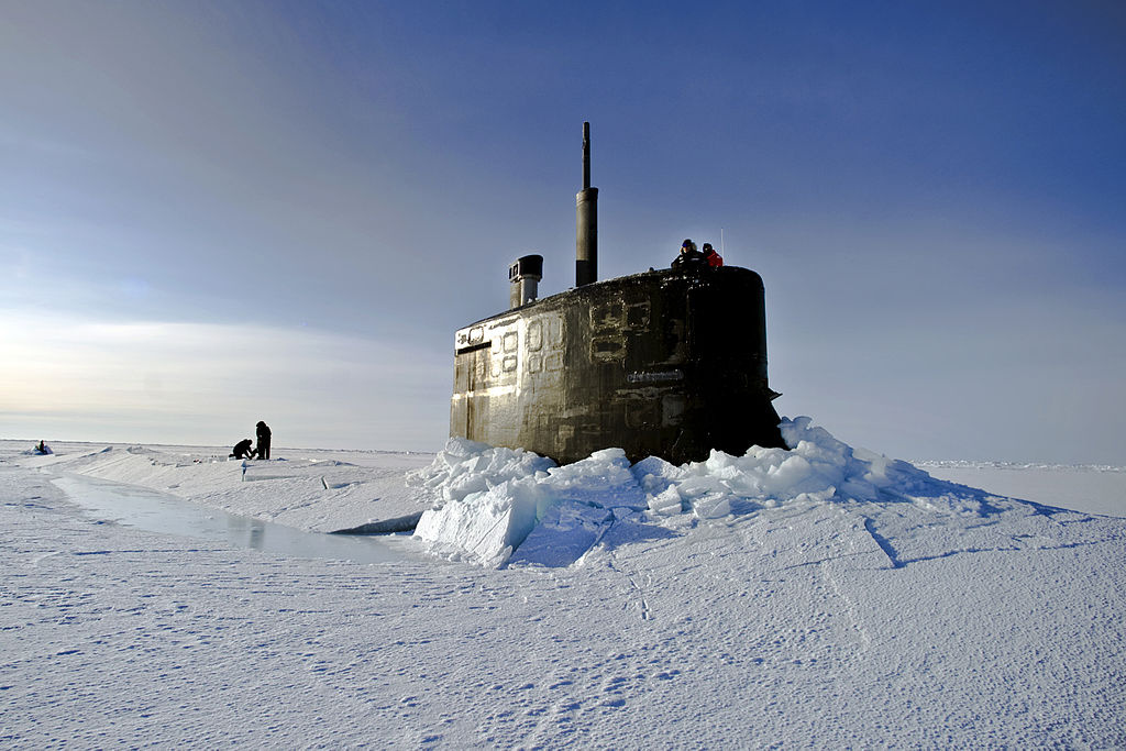 U.S. Navy sailors and members of the Applied Physics Laboratory Ice Station clear ice from the hatch of the USS Connecticut as it surfaces above the ice in the Arctic Ocean. Wikimedia Commons/Public domain