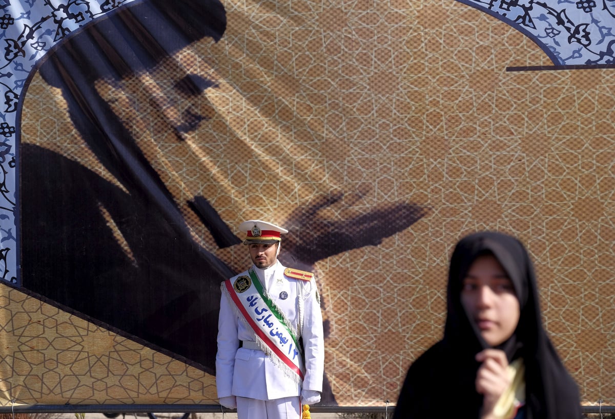 An Iranian soldier stands guard in front of a picture of Iran's late leader Ayatollah Ruhollah Khomeini during the anniversary ceremony of Iran's Islamic Revolution in Behesht Zahra cemetery, south of Tehran
