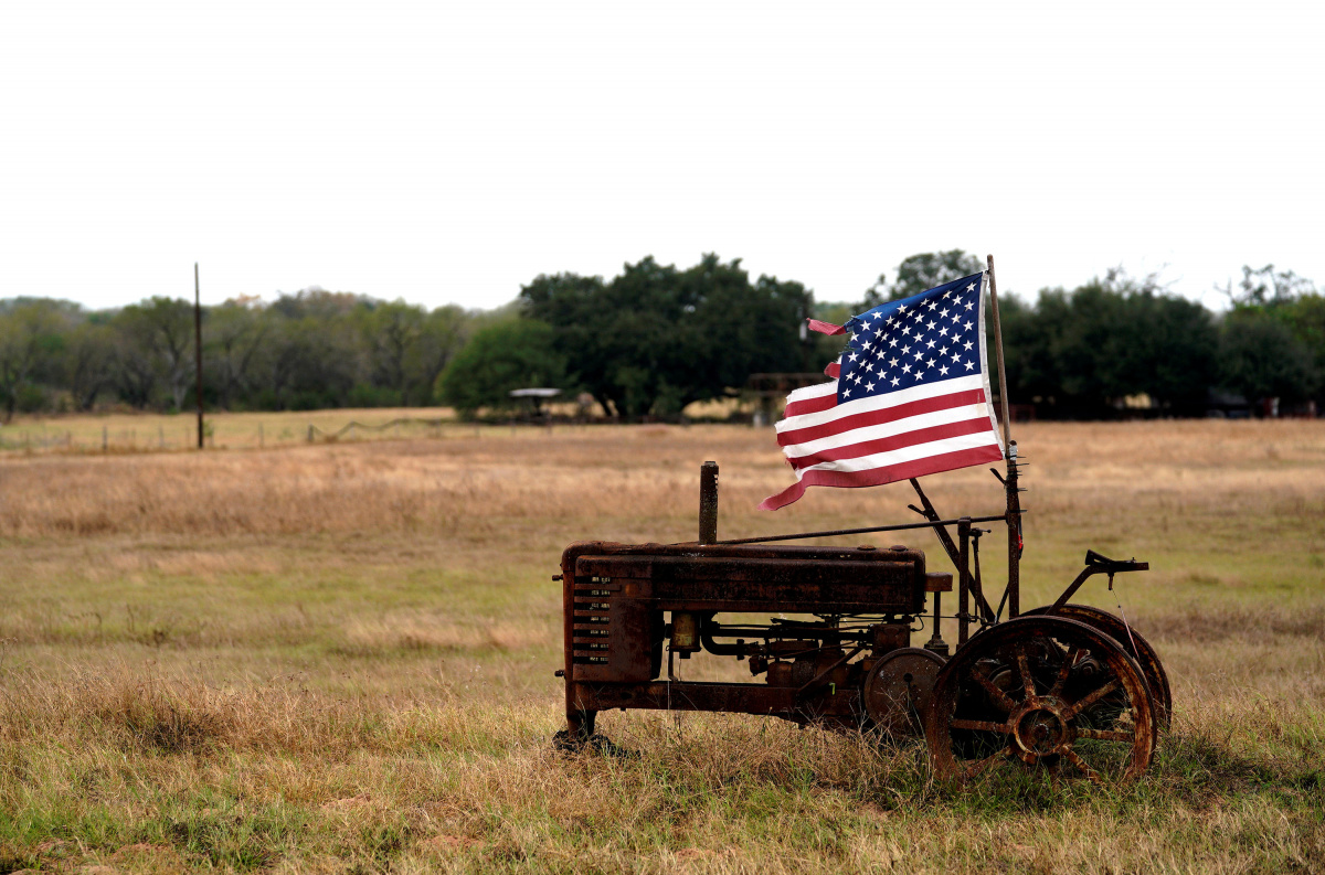A tattered U.S. flag flies on an old tractor in a farm field outside Sutherland Springs, near the site of the shooting at the First Baptist Church of Sutherland Springs,Texas