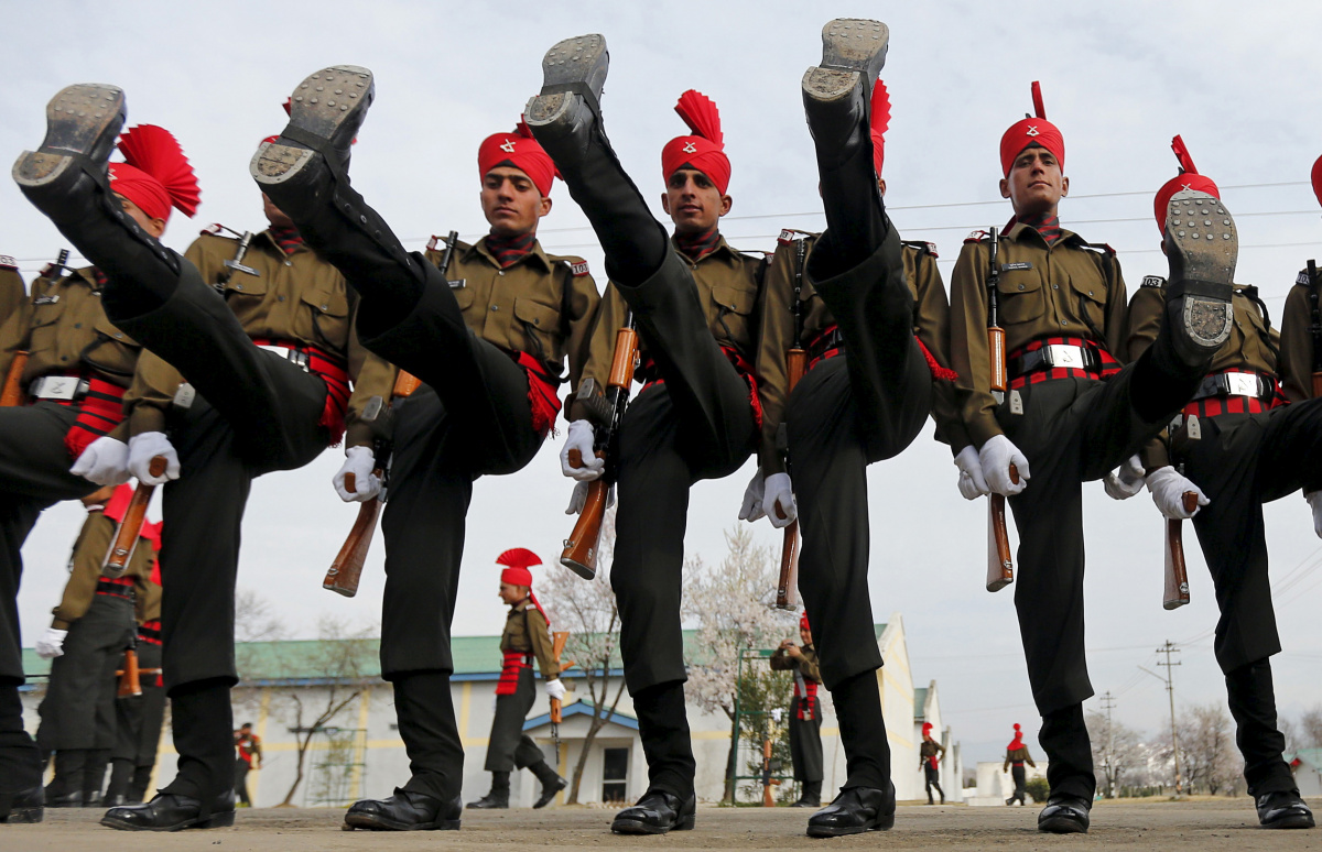 Indian army recruits wearing their ceremonial uniform perform a salute as they pose before their passing out parade at a garrison in Rangreth on the outskirts of Srinagar