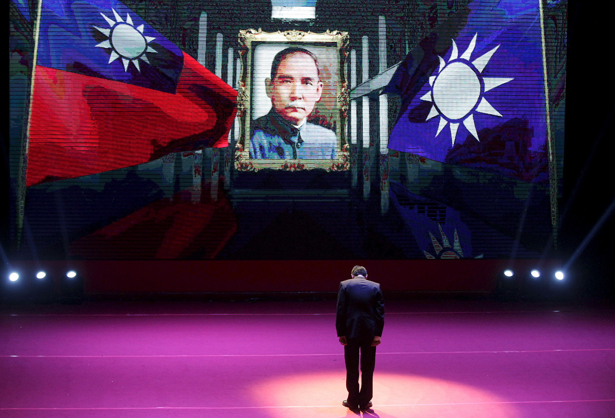 Taiwan's ruling Nationalist Kuomintang Party (KMT) chairman and presidential candidate Eric Chu bows to Taiwan's national flag, KMT's flag and a portrait of the founding father of the Republic of China, Dr. Sun Yat-sen at a party congress in Taipei