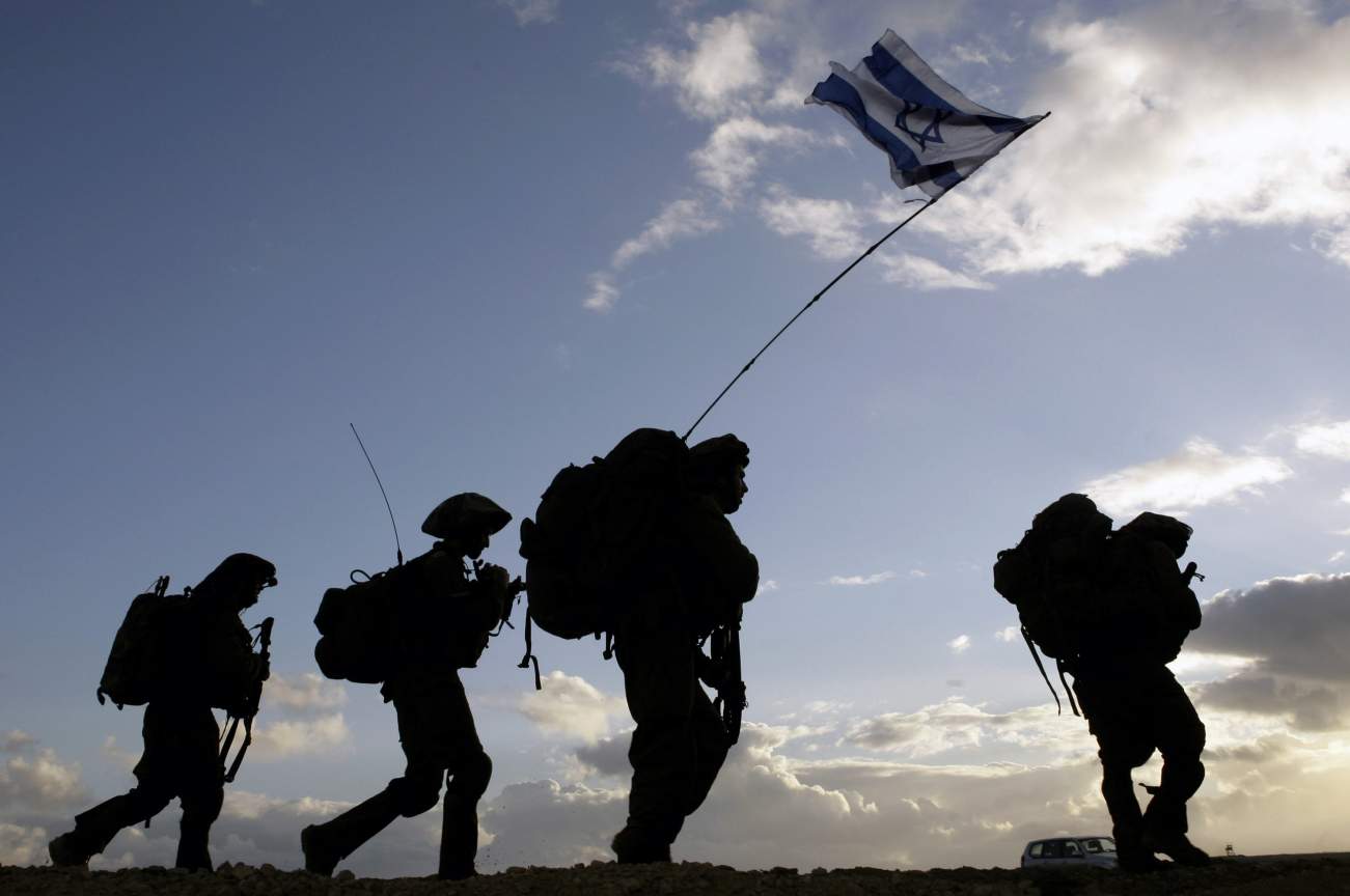 Israeli soldiers cross the Gaza border back to Israel early morning
