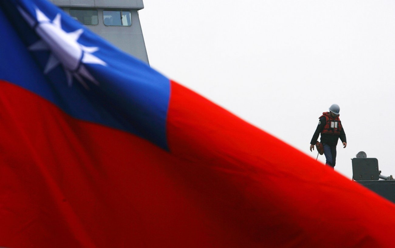 A soldier walks past a Taiwan flag during a navy exercise in Kaohsiung January 26, 2010. The U.S. and China are currently at odds over arms sales to Taiwan, according to local media. REUTERS/Nicky Loh
