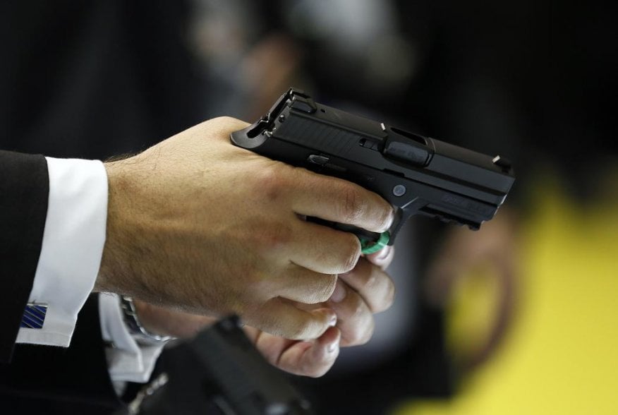 A man holds a Sig Sauer pistol during the Defence Security Equipment International (DSEI) arms fair at ExCel in London September 10, 2013. REUTERS/Stefan Wermuth