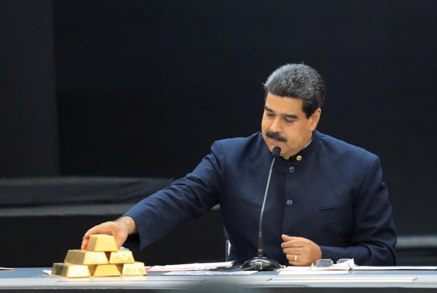 Venezuela's President Nicolas Maduro touches a gold bar as he speaks during a meeting with the ministers responsible for the economic sector at Miraflores Palace in Caracas, Venezuela March 22, 2018. REUTERS/Marco Bello