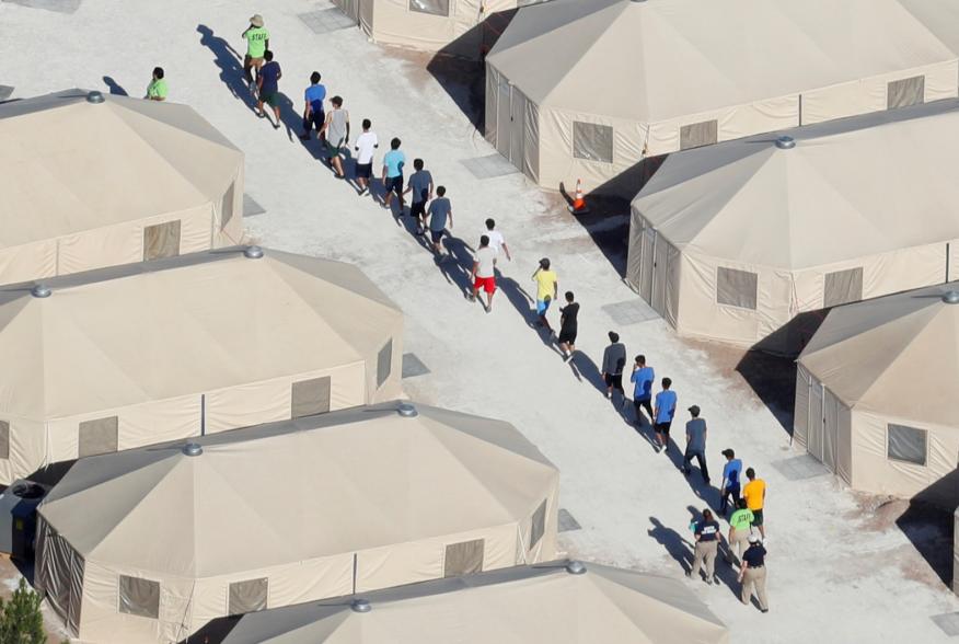 Immigrant children now housed in a tent encampment under the new "zero tolerance" policy by the Trump administration are shown walking in single file at the facility near the Mexican border in Tornillo, Texas, U.S. June 19, 2018. REUTERS/Mike Blake