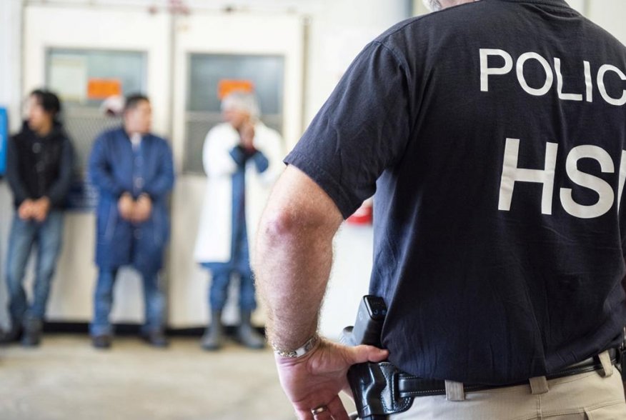 Image: Homeland Security Investigations (HSI) officers from Immigration and Customs Enforcement (ICE) look on after executing search warrants and making some arrests at an agricultural processing facility in Canton, Mississippi, U.S. in this August 7, 201