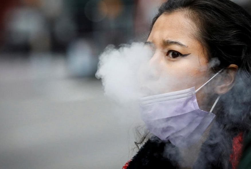 A woman exhales after vaping in Times Square, during the coronavirus disease (COVID-19) outbreak, in New York City, U.S., March 31, 2020. REUTERS/Brendan McDermid