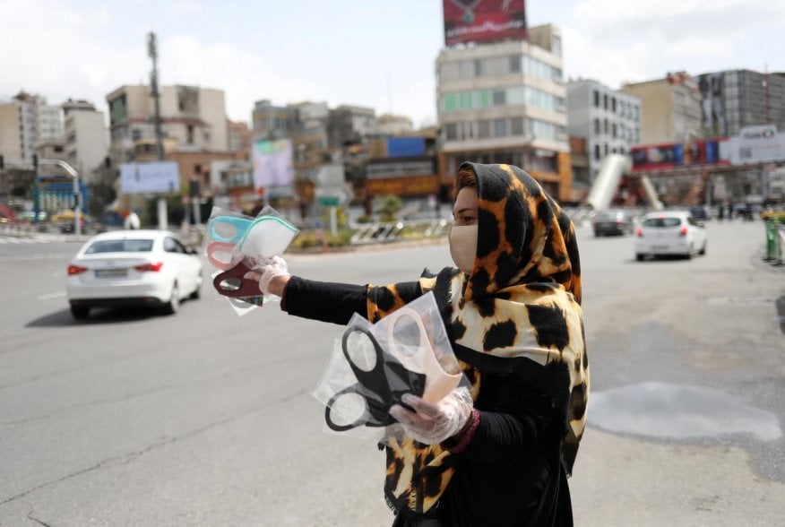 A woman wears a protective face mask and gloves, amid fear of the coronavirus disease (COVID-19), as she sells the masks in Tajrish square in Tehran, Iran April 2, 2020. WANA (West Asia News Agency)/Ali Khara via REUTERS
