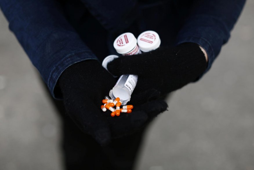 A fentanyl user displays a "safe supply" of opioid alternatives, including morphine pills, provided by the local health unit to combat overdoses due to poisonous additives and to support addicts and the homeless into practicing social distancing to help s