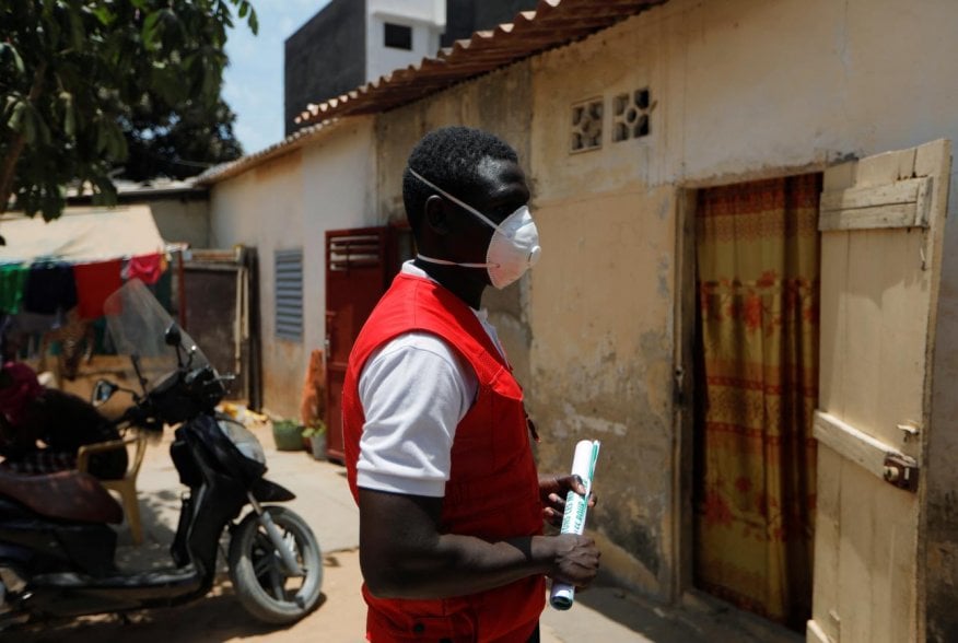 Cheikhou Dembele, 25, Senegalese Red Cross volunteer, waits outside a house during an awareness campaign to prevent the spread of coronavirus disease (COVID-19), in Dakar, Senegal April 18, 2020. REUTERS/Zohra Bensemra