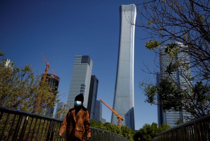 A woman wearing a protective mask walks near the Central Business District on a “blue sky day" in Beijing as the spread of the novel coronavirus disease (COVID-19) continues, in China April 22, 2020. REUTERS/Thomas Peter