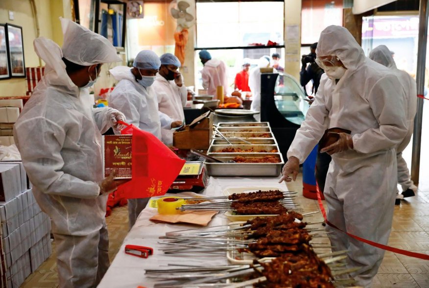 A man wears a protective suit as he purchases iftar meals from a restaurant during Ramadan, amid concerns over the coronavirus disease (COVID-19) outbreak in Dhaka, Bangladesh, April 29, 2020. REUTERS/Mohammad Ponir Hossain