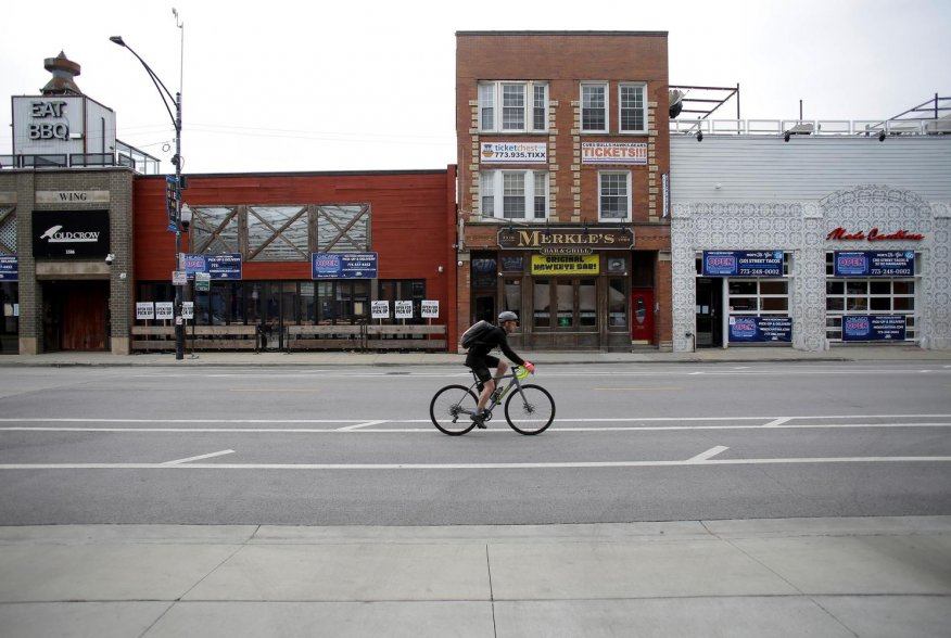 A bicyclist rides past closed businesses in the Wrigleyville neighborhood near the Chicago Cubs home stadium of Wrigley Field, which has been closed due to the coronavirus disease (COVID-19) restrictions in Chicago, Illinois, U.S. May 20, 2020. Picture ta
