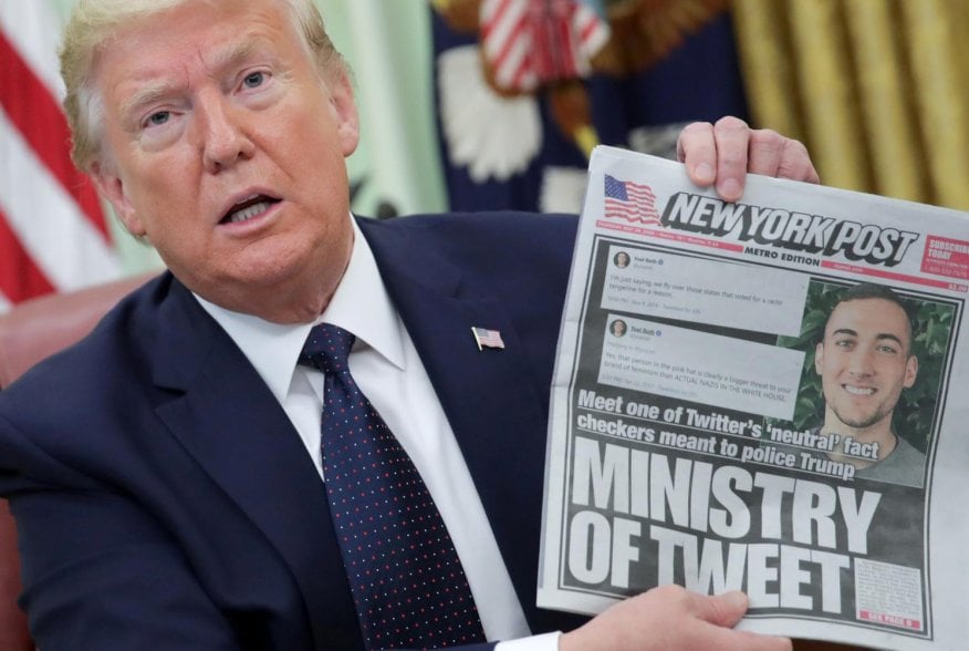 U.S. President Donald Trump holds up a front page of the New York Post as he speaks to reporters while discussing an executive order on social media companies in the Oval Office of the White House in Washington, U.S., May 28, 2020. REUTERS/Jonathan Ernst