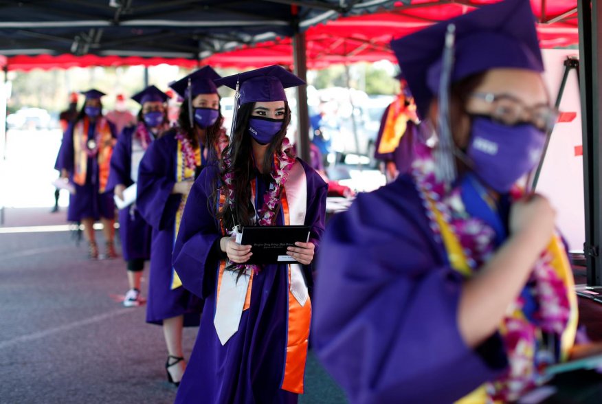 Compton Early College High School graduating students wait after picking up their diplomas in a parking lot during a drive-thru graduating ceremony, during the outbreak of the coronavirus disease (COVID-19) in Compton, California U.S. June 10, 2020. REUTE