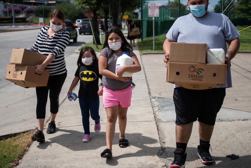 Members of the Rodriguez family carry groceries distributed by the Houston Food Bank for residents affected by the economic fallout caused by the coronavirus disease (COVID-19) pandemic in Houston, Texas, U.S., July 18, 2020. REUTERS/Adrees Latif