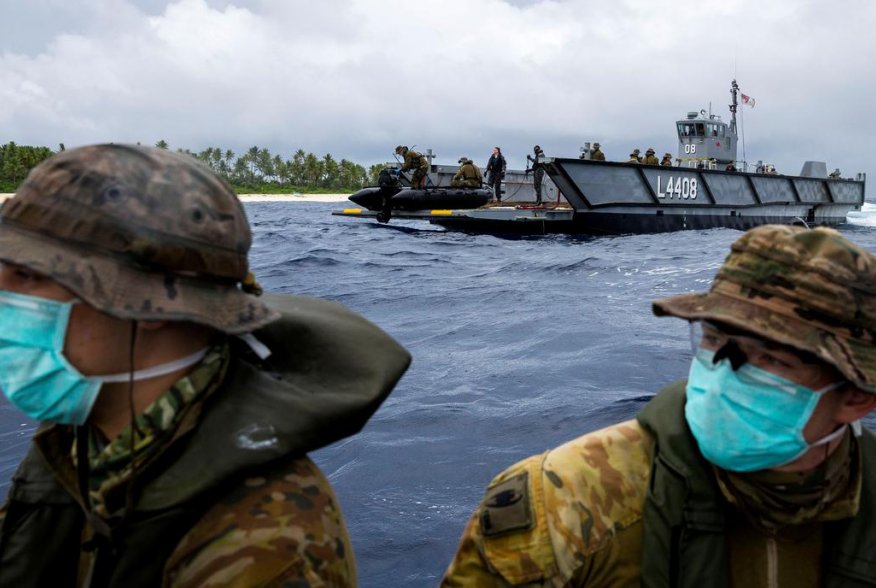 Australian Army soldiers from 2nd Battalion, the Royal Australian Regiment, launch a zodiac inflatable boat from one of HMAS Canberra's Landing Craft to deliver food and supplies to three stranded mariners from the Federated States of Micronesia following