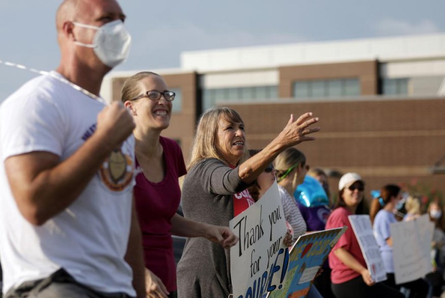 Supporters of the Cherokee County School District's decision to reopen schools to students during the coronavirus disease (COVID-19) pandemic cheer on faculty arriving to the district's headquarters, the Dr. Frank R. Petruzielo Educational Services Facili