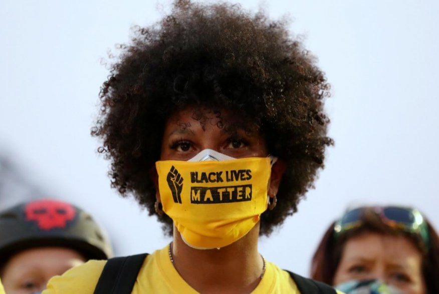 A protester with the "Black Lives Matter" slogan printed on her face mask joins a protest against racial inequality and police violence in Portland, Oregon, U.S., July 26, 2020. REUTERS/Caitlin Ochs