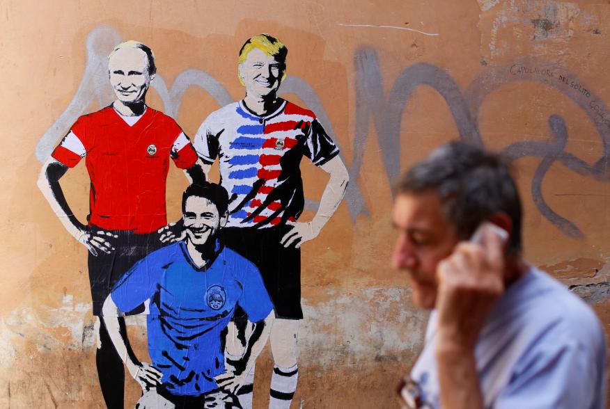 A man walks past a mural signed by "TV Boy" and depicting Russian President Vladimir Putin, U.S. President Donald Trump and Italian Prime Minister Giuseppe Conte as soccer players in downtown Rome, Italy June 15, 2018. REUTERS/Tony Gentile NO RESALES. NO 