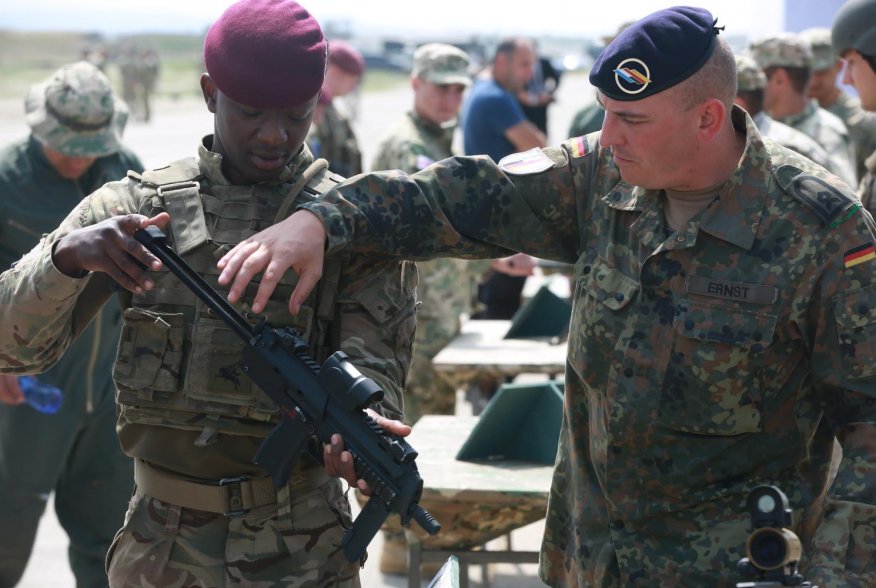 A German soldier with the 291st Infantry Division (right), explains the functions of the MP7-PDW to a British soldier (left) assigned to 2nd Parachute Regiment, Vaziani Airfield, Republic of Georgia, July 30, 2017. U.S. Army/Joseph E. Cannon.