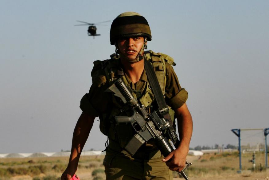 An Israeli soldier watches a chopper land on a military area in Kerem Shalom at the border with Gaza June 28, 2006. Israel fired artillery shells into the northern Gaza Strip on Wednesday as troops and tanks prepared to widen an offensive aimed at forcing