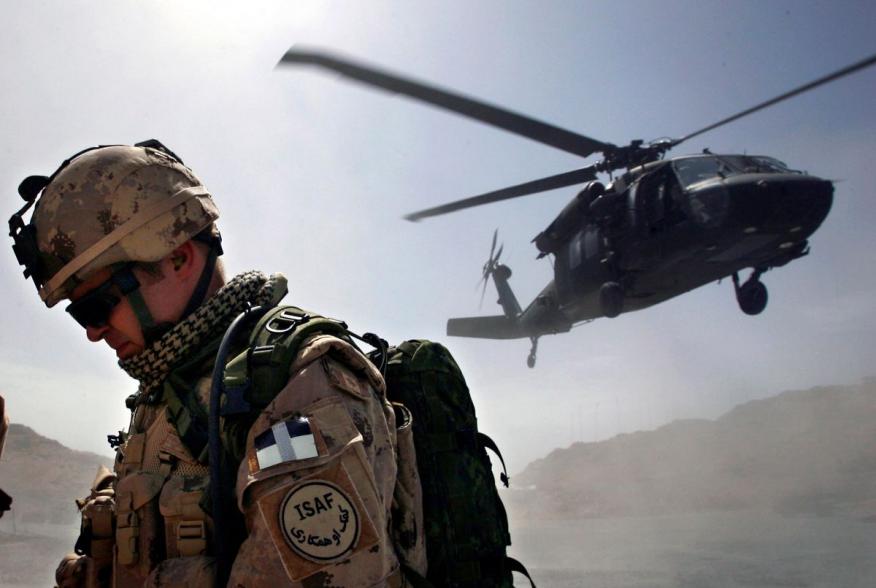 A Canadian soldier from the NATO-led coalition force turns his back away from a dust cloud kicked up by a Blackhawk helicopter taking off from the forward operating base of Ma'sum Ghar, Afghanistan, July 1, 2007. REUTERS/ Finbarr O'Reilly (AFGHANISTAN)