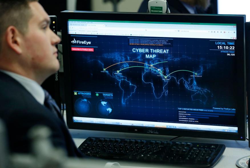 A Department of Homeland Security worker listens to U.S. President Barack Obama talk at the National Cybersecurity and Communications Integration Center in Arlington, Virginia, January 13, 2015. REUTERS/Larry Downing (UNITED STATES - Tags: POLITICS SCIENC