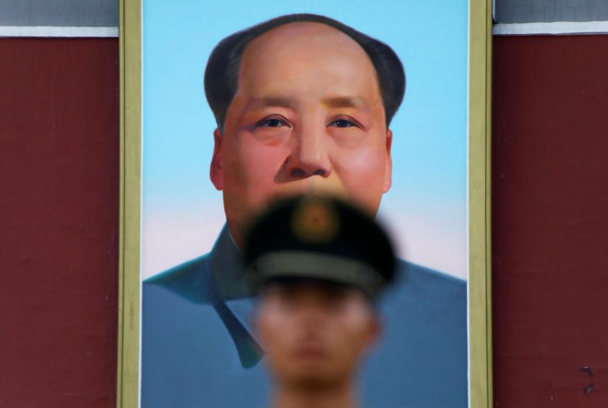 A paramilitary policeman stands guard under a giant portrait of late Chinese Chairman Mao Zedong at the Tiananmen gate in Beijing, China July 14, 2017. REUTERS/Damir Sagolj