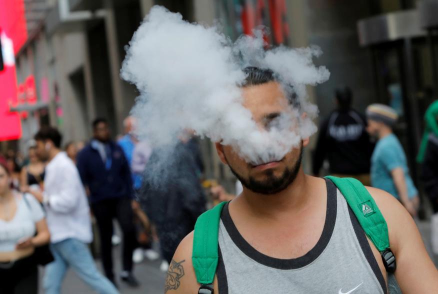 A man uses a vape as he walks on Broadway in New York City, U.S., September 9, 2019. REUTERS/Andrew Kelly
