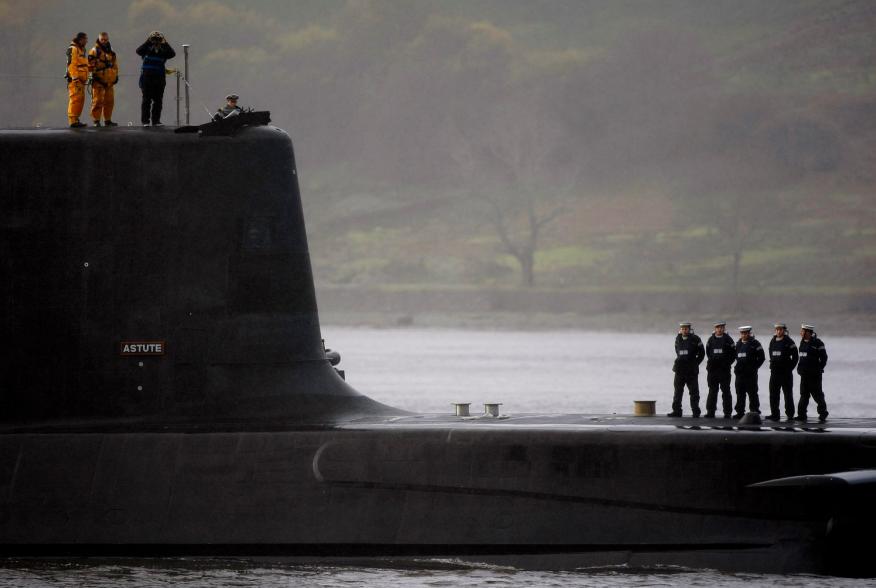 Crew from HMS Astute, the first of the biggest hunter-killer submarines to be ordered by Britain's Royal Navy, look out as they sail into the River Clyde and up the Gareloch to her new home at HM Naval Base Clyde in Faslane near Glasgow, Scotland November