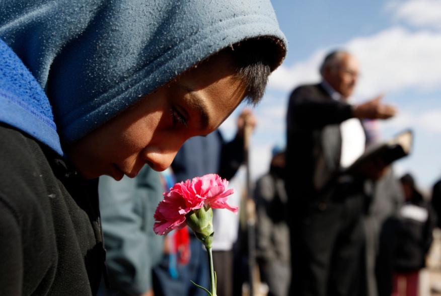 A boy holds a flower during the funeral of 16-year-old Karina Ivette Delgado in Ciudad Juarez February 3, 2011. Delgado was killed in a crossfire between suspected car thieves and federal agents on Sunday, according to local media.  REUTERS/Gael Gonzalez 