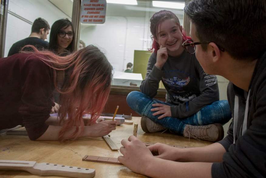 Students work together when they build guitars in class, reinforcing what they learn.  James Cordero, CC BY-SA