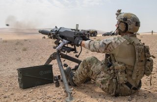 A soldier assigned to U.S. Army Special Operations Command demonstrates firing positions on the Mk 47 Strike 40mm grenade launcher to a member of the Saudi Arabian Naval Special Forces during joint forces weapons training in a tactical training area in Am