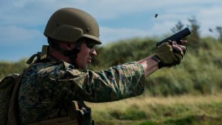 Sgt. Devin Hughes, a member of the Marine Corps Shooting Team, fires a round at a target during the Royal Marines Operational Shooting Competition at Altcar Range near Hightown, England, Sept. 8, 2014. (U.S. Marine Corps photo by Cpl. Cameron Storm/Releas