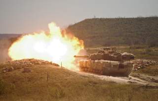 A burst of fire erupts from the muzzle of a 2nd Armored Brigade Combat Team, 1st Cavalry Division M1 Abrams tank during gunnery training at Fort Hood, Texas.