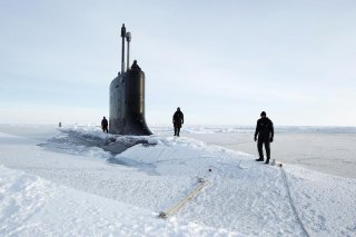 U.S. Navy safety swimmers stand on the deck of the Virginia class submarine USS New Hampshire after it surfaced through thin ice during exercises underneath ice in the Arctic Ocean north of Prudhoe Bay, Alaska March 19, 2011. REUTERS/Lucas Jackson