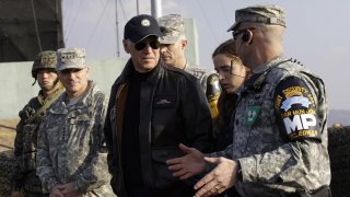 U.S. Vice President Joe Biden (C) is briefed by Lt. Col. Daniel Edwan (R), the commander of the Joint Security Area (JSA) Security Battalion at Observation Post Ouellette, during a tour of the Demilitarized Zone (DMZ), the military border separating the t