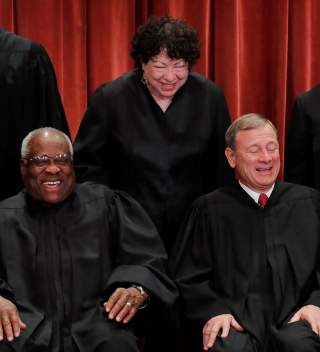 U.S. Supreme Court Associate Justice Sonia Sotomayor makes Associate Justice Clarence Thomas and Chief Justice John Roberts laugh as they pose together for their group portrait at the Supreme Court in Washington, U.S., November 30, 2018. REUTERS/Jim Young