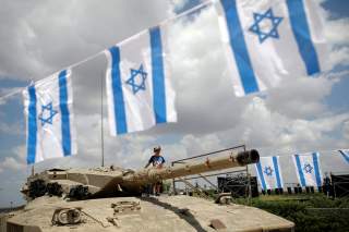A boy stands atop an old tank during Memorial Day ceremony at Latrun's armoured corps memorial site, Israel May 8, 2019. REUTERS/Corinna Kern
