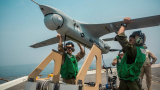 U.S. Navy Marines lift an RQ-21A Blackjack unmanned aerial system (UAS) onto a launcher before flight operations aboard the amphibious transport dock ship USS John P. Murtha (LPD 26) in the Gulf, in this undated handout picture released by U.S. Navy on Ju
