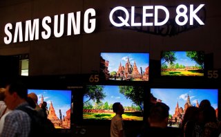 People stand in front of the QLED 8K screens at the hall of Samsung at the IFA consumer tech fair in Berlin, Germany, September 6, 2019. REUTERS/Hannibal Hanschke