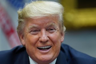 President Donald Trump laughs as he speaks while participating in a 