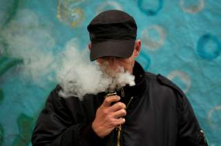 FILE PHOTO: A man poses for a picture, as he vapes at home in La Paz, Bolivia, February 2, 2019. REUTERS/David Mercado/File Photo