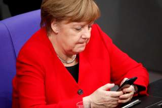 FILE PHOTO: German Chancellor Angela Merkel checks her phone at the lower house of parliament (Bundestag), ahead of a Brussels summit for Brexit delay discussions, in Berlin, Germany March 21, 2019. REUTERS/Hannibal Hanschke/File Photo