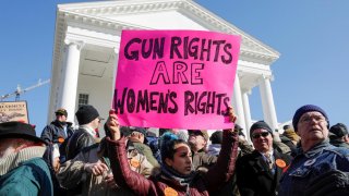 A activist holds up a sign supporting gun rights for women during a rally inside the no-gun zone in front of the Virginia State Capitol building in Richmond, Virginia, U.S. January 20, 2020. REUTERS/Jonathan Drake
