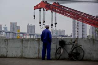 FILE PHOTO: FILE PICTURE: A worker stands by a dock next to the Huangpu river in Shanghai, Nov. 25, 2014. REUTERS/Aly Song/File Photo
