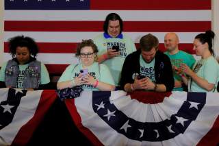 Supporters of Democratic 2020 U.S. presidential candidate and U.S. Senator Elizabeth Warren (D-MA) look at their mobile phones before she speaks at her Iowa Caucus rally in Des Moines, Iowa, U.S., February 3, 2020. Picture taken February 3, 2020. REUTERS/